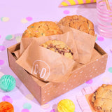 3 x New York Cookies, The Birthday Box by Crumbs & Doilies in a gift box with festive decorations on a pastel background